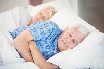 Elderly couple sleeping together.