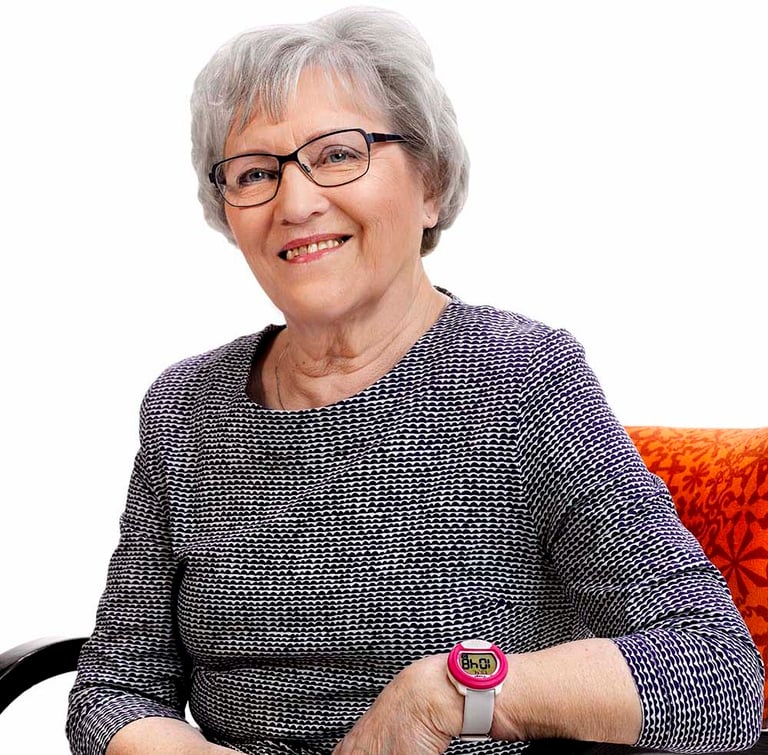 Elderly woman sitting in a chair and wearing a care watch.