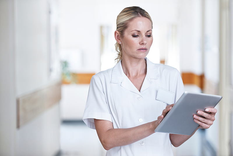 Nurse working in a care institute and looking an ipad.