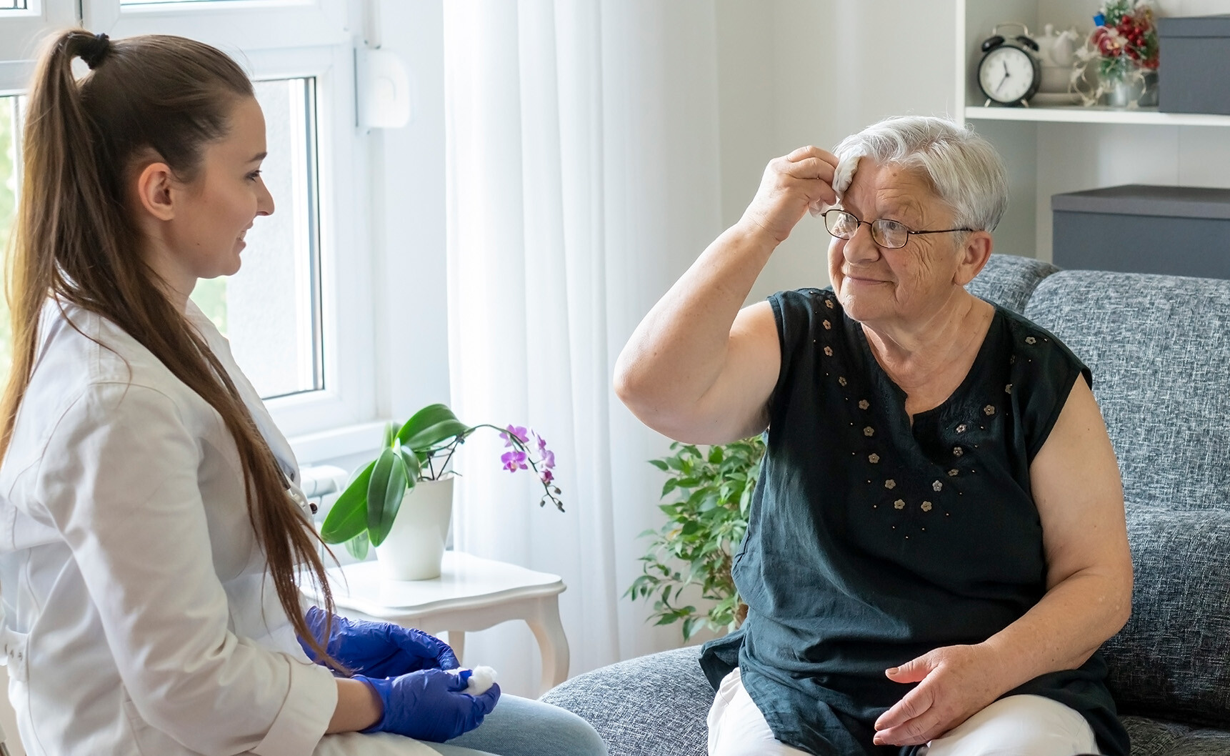 Elderly woman sitting down with a nurse